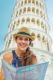 Happy young woman with map in front of leaning tower of pisa, tu