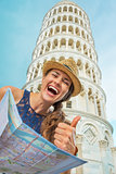 Happy young woman with map in front of leaning tower of pisa sho