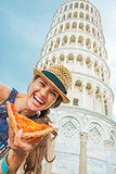 Happy young woman with pizza in front of leaning tower of pisa, 
