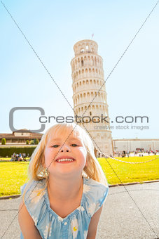 Portrait of happy baby girl in front of leaning tower of pisa, t