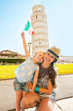 Portrait of happy mother and baby girl with italian flag in fron