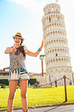 Funny young woman supporting leaning tower of pisa and showing t