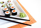  Delicious sushi rolls on white plate with chopsticks 