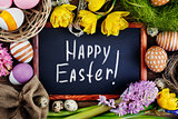 Black board on wooden table with text - Happy Easter.   