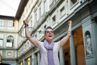 Happy young woman near uffizi gallery rejoicing in florence, ita