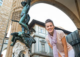 Portrait of happy young woman in front of statue perseus with th