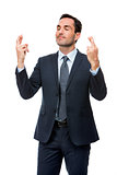 businessman with eyes closed and fingers crossed