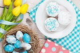 Easter background with blue and white eggs in nest, yellow tulip