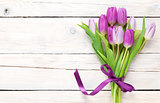 Purple tulip bouquet over wooden table