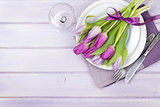 Purple tulip bouquet over plate