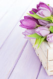 Purple tulips box over wooden table