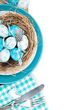 Easter eggs nest on plate with silverware