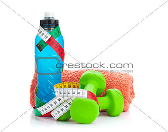 Two green dumbells, tape measure and drink bottle. Fitness and h