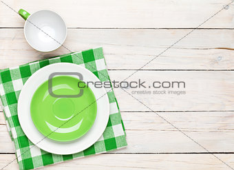 Empty plate, cup and towel over wooden table background