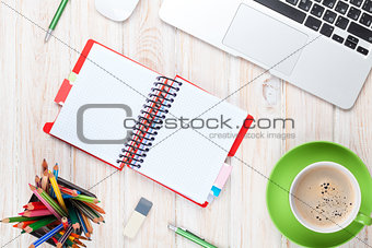 Office desk table with computer, supplies and coffee cup