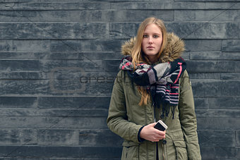 Woman in Winter Outfit in Front Old Gray Wall