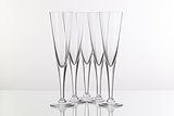 Five champagne glasses on a glass desk