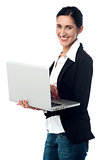 Cheerful corporate woman using laptop