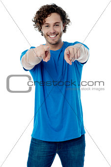 Smiling young guy pointing at you