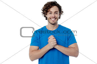 Happy young man with clasped hands