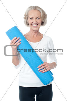 Gym instructor holding blue exercise mat