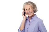 Senior smiling lady attending phone call