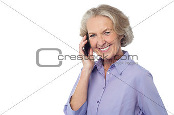 Senior smiling lady attending phone call