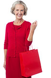Senior woman holding red shopping bag
