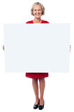 Glamorous woman holding blank ad board