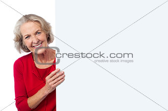Aged woman holding blank ad board