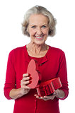 Senior woman with heart shaped gift box