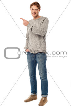 Casual young man pointing away