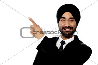 Smiling businessman pointing away