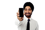 Salesman displaying newly launched mobile phone