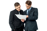 Businessmen evaluating deal documents