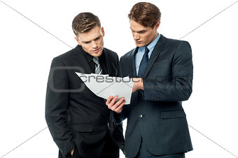 Businessmen evaluating deal documents