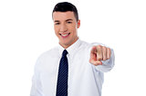 Young smiling businessman pointing you out