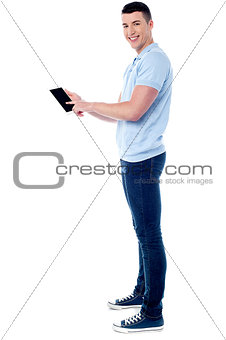 Smiling guy operating his tablet pc