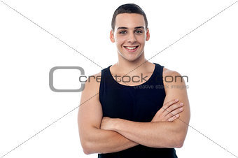 Smiling young fitness guy, arms crossed