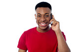 Smiling guy attending a phone call