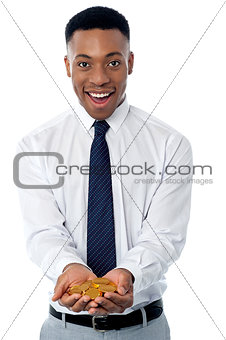 Young male executive holding gold coins