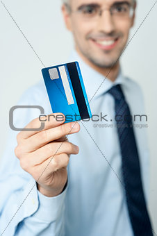 Cheerful businessman holding credit card