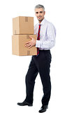 Corporate man holding stack of parcel boxes
