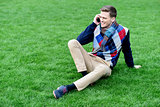 Happy young man using mobile phone on park