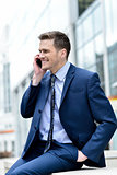 Smiling businessman talking in his mobile phone