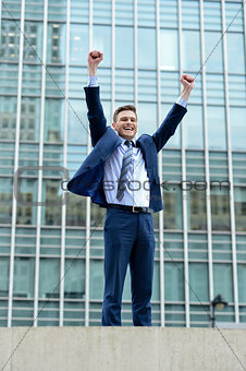 Excited businessman raising his arms