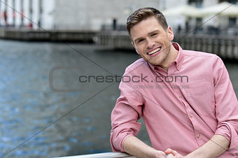 Handsome young man posing near railing