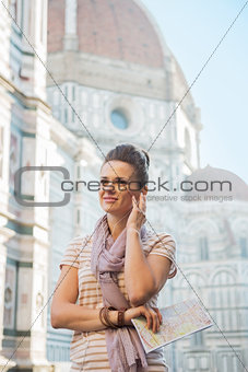 Happy young woman with map and audio guide in front of cattedral