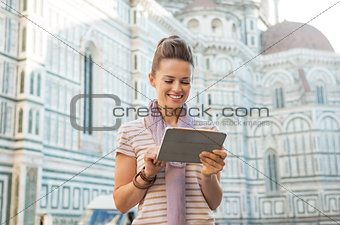 Happy young woman with tablet pc in front of cattedrale di santa