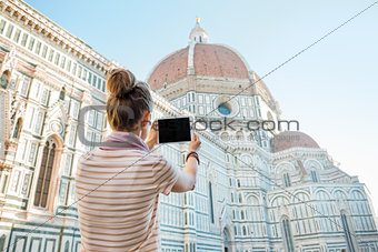 Young woman taking photo with tablet pc of cattedrale di santa m
